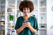 © Ivan - Successful young african american woman receiving good news on her mobile phone