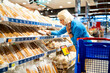 © Alfonso Soler - Senior woman buying bread at supermarket bakery section