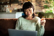 © Davor - Smiling woman shopping online with credit card at home