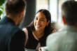 © Geber86 - Smiling woman chatting with colleagues at cafe table