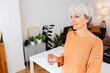 © Xavier Lorenzo - Happy senior adult woman holding a glass of water in the morning at home. Healthy life habit, lifestyle concept