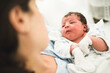© Antonio Recena - Newborn baby boy sleeping in crib, holding by his mother