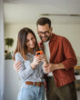© Miljan Živković - Smiling couple sharing content on smart phone at home