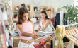 © JackF - Teen girl shopping in clothing department, buying summer tank top. Off line clothing store from leading retailers. Buyer browsing through colorful apparel on display rack