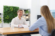 © New Africa - Smiling recruiter and candidate having job interview at table in office