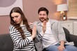 © New Africa - Embarrassed woman ignoring flirting man on sofa at home, selective focus