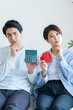 © ponta1414 - 悩む電卓を持つ男性とがま口財布を持つ女性