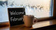 © Muhammad - Welcome February chalkboard sign with coffee cup on wooden table by snowy window view