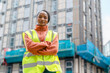 © Iryna - Construction worker stands in front of building site holding arms crossed