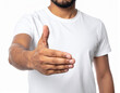 © theshooter - Hombre joven con camiseta blanca extendiendo la mano en gesto de saludo y bienvenida, concepto de cercanía, bienvenida, confianza, trato humano, acuerdo de trabajo, honestidad y compromiso