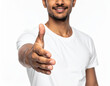 © theshooter - Hombre joven con camiseta blanca extendiendo la mano en gesto de saludo y bienvenida, concepto de cercanía, bienvenida, confianza, trato humano, acuerdo de trabajo, honestidad y compromiso
