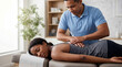 © Таня Андреева - Professional male chiropractor in blue polo performing back adjustment on black female patient lying on table in bright clinic.