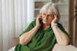 © Anastasiya - Elderly caucasian woman listening on smartphone with worried expression, senior female receiving concerning call, emotional stress in retirement lifestyle indoors