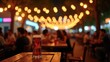 © Mystery - Glass of dark beer on wooden table in crowded pub with string lights bokeh, lively bar atmosphere with blurred people dining, concept of brewery, nightlife, hospitality