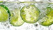 © EKAN KUDAH - Close-up of lime slices submerged in bubbly water, with ice cubes, against white