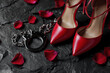 © ink drop - Red high heel shoes with handcuffs and rose petals on black background for love and sensual romance