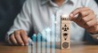© Helen - Man stacking wooden cubes with skill icons, showing business growth up arrow. Career development and personal improvement concept.