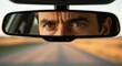 © twilight mist - Intense adult male gaze reflects in the interior rearview mirror while traveling on a rural road.