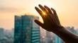 © Meera Graphic  - Hand reaching for sun over modern cityscape at sunset
