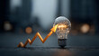 © Jack - Glowing light bulb sits in front of a chart with an arrow trending upward, symbolizing innovation and success for business growth