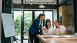© mojo_cp - Female leader guiding new staff member at office with career advice and skill development discussion