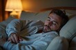 © Yuliia - Man peacefully sleeping on cozy sofa at home in his pajamas