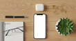 © PixelOriel - Smartphone blank screen on wood desk with pen notebook glasses earbuds