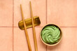 © Pixel-Shot - Bowl with wasabi paste and chopsticks on beige tile background