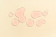 © Pixel-Shot - Drops of pink cosmetic oil on beige background