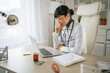 © Miljan Živković - Female asian doctor working on laptop in clinic