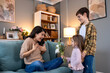 © Graphicroyalty - Happy mother receiving flowers from her children at home. Surprised woman sitting on sofa as kids give her a bouquet. Family celebration, Mothers Day, and love concept in cozy modern living room.