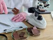 © Nadzeya - Person examines chocolate samples in a laboratory setting during a research session concept