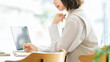 © Trickster* - ノートパソコンを使いながらメモを書くビジネスウーマン, Businesswoman Writing Notes While Using Laptop