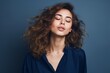 © nsit0108 - Woman with eyes closed finding serenity, wind blowing through her curly hair portrait
