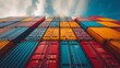 © Fatoniyah - Global Trade Logistics: A vibrant tower of shipping containers, a visual symphony of colors, stacked high against a dynamic cloudy sky, conveying global trade and supply chain.