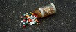 © vxnaghiyev - Medication plastic bottle fell outside, drugs scattered on the ground, tablets and capsules spilled, unsafe to ingest