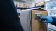 © Chanoknan - Temperature control optimization for insulated package shipping with monitoring device interface and gloved hand interaction in warehouse cold chain logistics environment