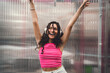 © BullRun - Young woman celebrates life with raised arms, smiling in headphones. Expressing joy, freedom, emotional release, and digital connection through music in vibrant personal style.