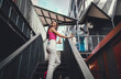 © BullRun - Woman in headphones walks up stairs, turning with smile, holding coffee. This scene blends tech, lifestyle, and self-motivation in a confident, independent urban rhythm.