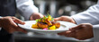 © Jhati - A chef presenting a plate of food with a beautifully prepared main course