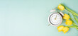 © Berit Kessler - Switch to daylight saving time in spring, summer time changeover, alarm clock with yellow tulip flowers