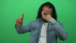 © Krakenimages.com - Man pinching nose with hand and gesturing with other hand in studio against bright green screen; disgust.
