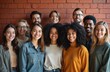 © Viktor - Diverse group of smiling people, men and women of various ethnicities and ages, stand together against a brick wall. They represent teamwork, community, and friendship in a modern setting.