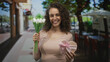 © Krakenimages.com - Woman holding white tulips and heart shaped gift box on a street cafe terrace, smiling and presenting flowers; romance joy.