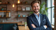 © Maryna - Smiling man in blue suit poses with folded arms in modern cafe. He looks friendly and pro, radiating success and confidence. The interior is stylish and inviting with warm lighting.