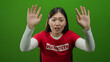© Krakenimages.com - Woman waving in red shirt with volunteer text on green background, showing enthusiasm and support, young and attractive.