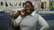 © Krakenimages.com - Smiling woman holding shopping bags poses near the iconic colosseum in rome, italy, showcasing happiness amidst a vibrant outdoor city street setting.