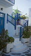 © Krakenimages.com - Woman walking up white stone steps holding the blue railing on a mykonos street; quiet contemplation travel.
