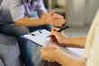 © Studio Romantic - Psychologist and patient talk in therapy session. Clinician writes notes on a clipboard as a man talks about mental health during consultation. Concept: mental health counseling process.