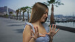 © Krakenimages.com - Caucasian girl in light blue dress pushes palms outward in rejecting gesture next to marina boat at port; disgust.